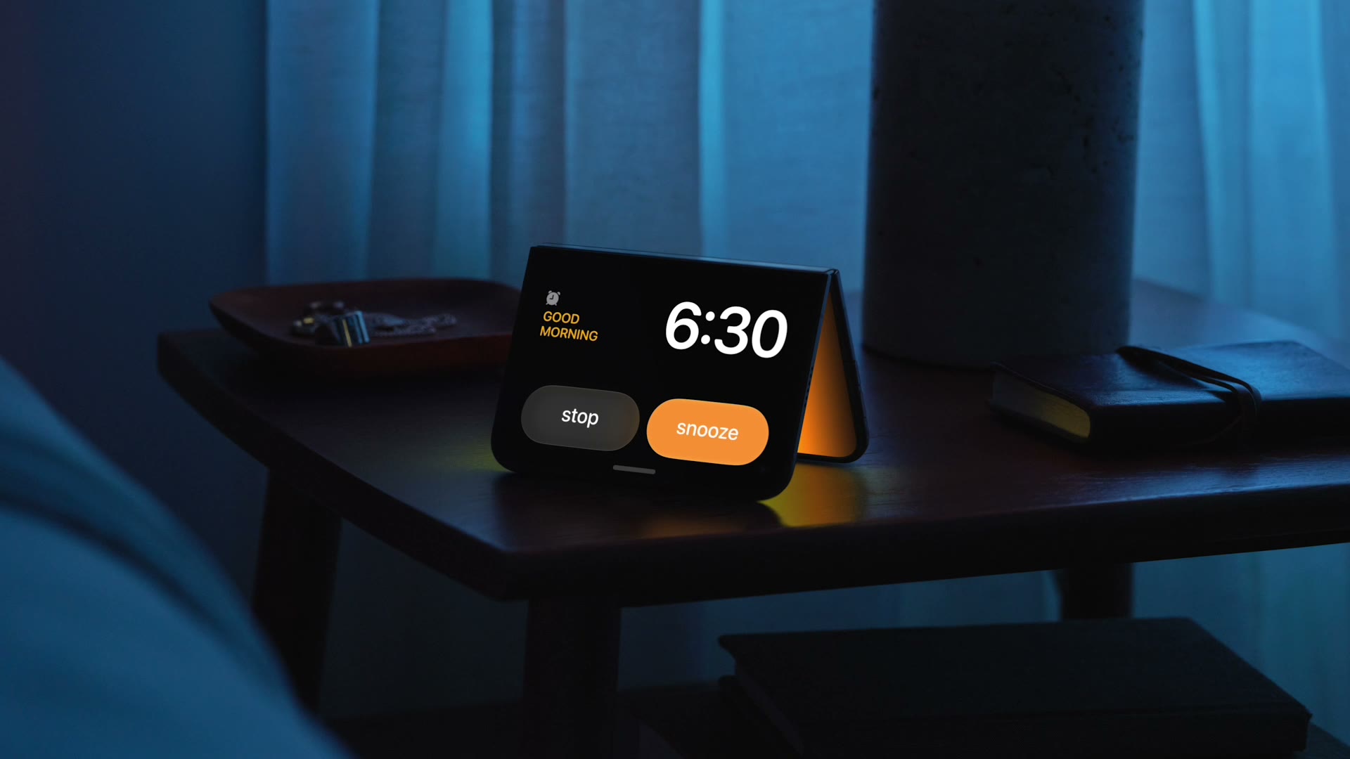 iPhone Duo in StandBy on a bedside table showing the morning clock